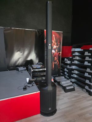 a large stack of speakers and speakers in a room