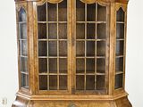 une vieille armoire en bois avec des portes vitrées dans une pièce