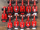 de nombreuses voitures de course rouges alignées sur le sol