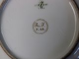 a white plate with a gold border and a blue and white plate with a gold border