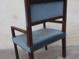a blue chair that is sitting in front of a white wall