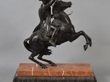a bronze statue of a man riding a horse on a marble base
