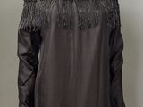 une robe noire avec des franges sur les épaules et les épaules