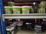 many buckets of paint on a shelf in a store