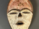 gros plan d'un masque en bois sur une surface grise
