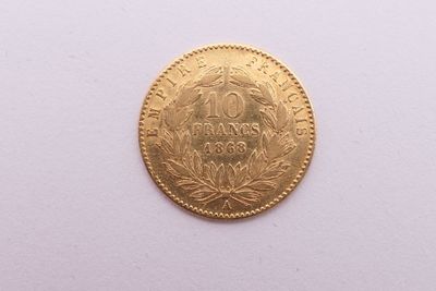 gros plan d'une pièce d'or sur une surface blanche