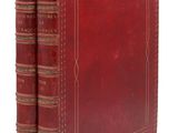 un livre en cuir rouge à deux dos, orné d'une bordure dorée