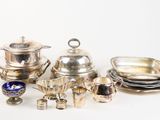 silver plated dishes and silverware on a white surface