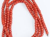 a close up of a red beaded necklace with a gold clasp