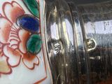 a close up of a silver object with a flower design on it