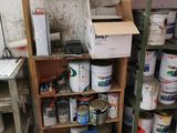 many cans of paint sitting on a shelf in a room