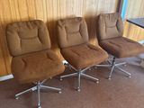 trois chaises dans une pièce où se trouvent une table et une chaise placées face à un mur