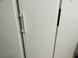 three white refrigerators in a room with tile flooring