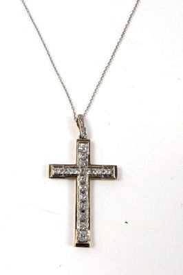 un gros plan d'une croix suspendue à un collier, sur fond blanc