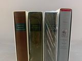 several books are lined up in a row on a white surface