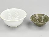 two white and green bowls sitting next to each other on a table