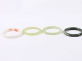 three pieces of green and white jade rings on a white surface