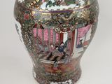 a vase with a lid sitting next to another vase