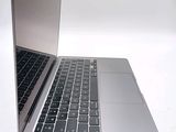 a silver laptop with a black keyboard on a white surface