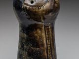 a close up of a vase with a face on it