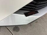 a close up of a white car with a sticker on the front of it