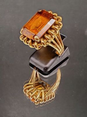 une bague en or surmontée d'une pierre orange