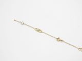 a gold chain bracelet with a small pearl and a small pearl on it