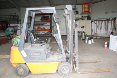a forklift in a warehouse with a lot of equipment