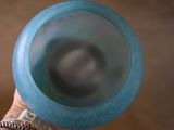 a person holding a blue frisbee in their hand
