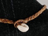 a close up of a necklace with a cowrie shell on a mannequin