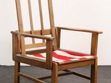 a wooden chair with a red and white cushion on it