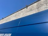 a blue van parked in front of a building