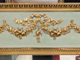 a mirror with a gold decoration on it in a room