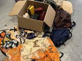 une boîte remplie de vêtements et d'autres objets posée par terre