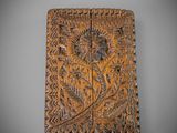 une plaque en bois ornée d'un motif de feuilles et de fleurs