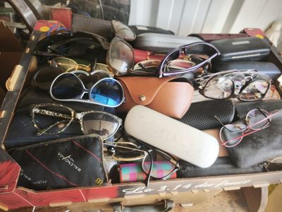 a suitcase full of glasses, sunglasses, and other items