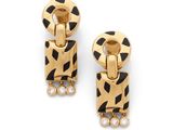 une paire de boucles d'oreilles noires et dorées ornées de pierres blanches