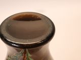 a brown vase with a green leaf design on it