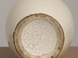 a close up of a white vase with a cracky surface