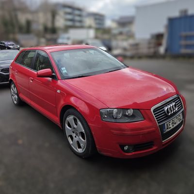 a red car parked in a parking lot next to a black car