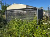 a fence that has a bunch of plants growing inside of it