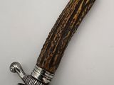 a close up of a knife with a wooden handle on a white surface