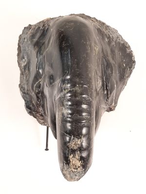 sculpture représentant une tête d'éléphant sur fond blanc, avec un fond blanc