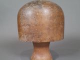 un petit objet en bois posé sur une table, sur fond gris