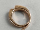 a close up of a gold ring on a white surface