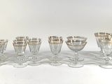 six wine glasses are lined up in a row on a white surface