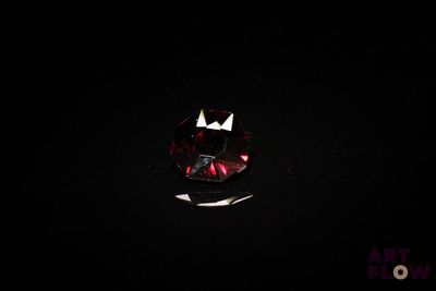 un gros plan d'un losange rouge et blanc sur une surface noire