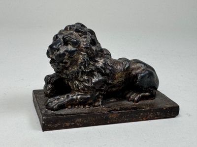 une statue représentant un lion assis sur un socle