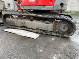 an image of a red and black excavator sitting on the ground