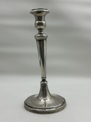 a silver candle holder sitting on a white table